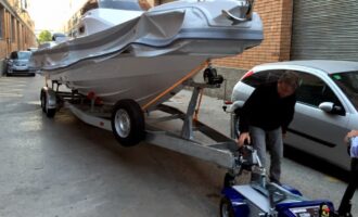 Heavy-duty electric tow tug moving a boat trailer