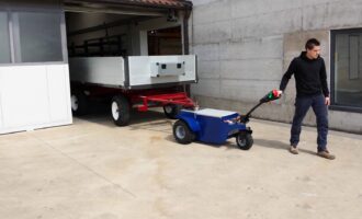 Heavy-duty electric tow tug towing an industrial trailer