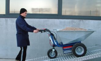 Battery-powered wheelbarrow moving materials up a ramp